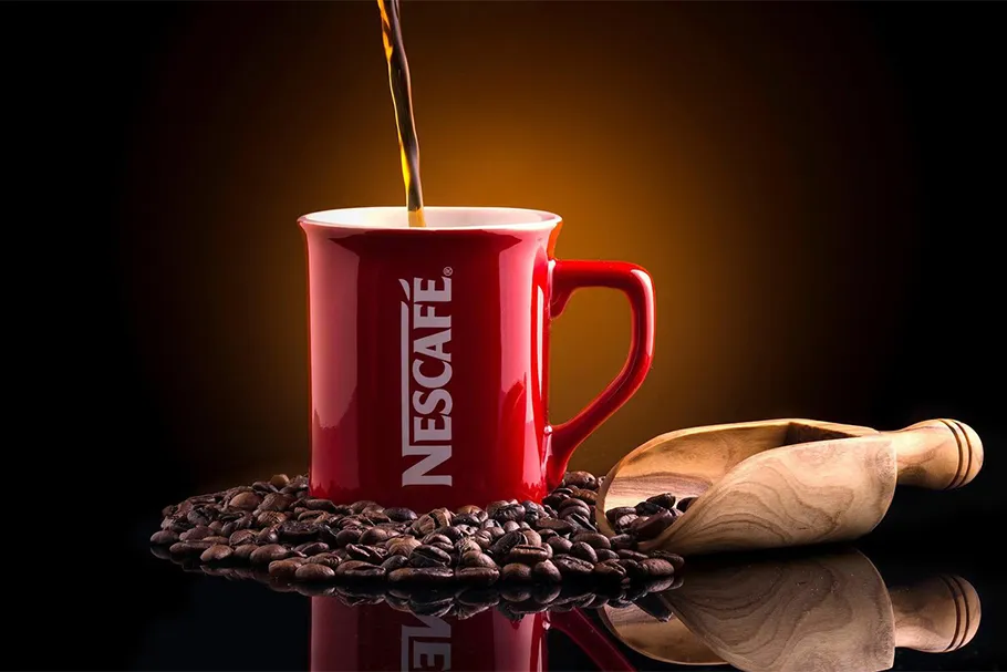 Фотография с чашкой кофе, стоящей среди кофейных зерен
